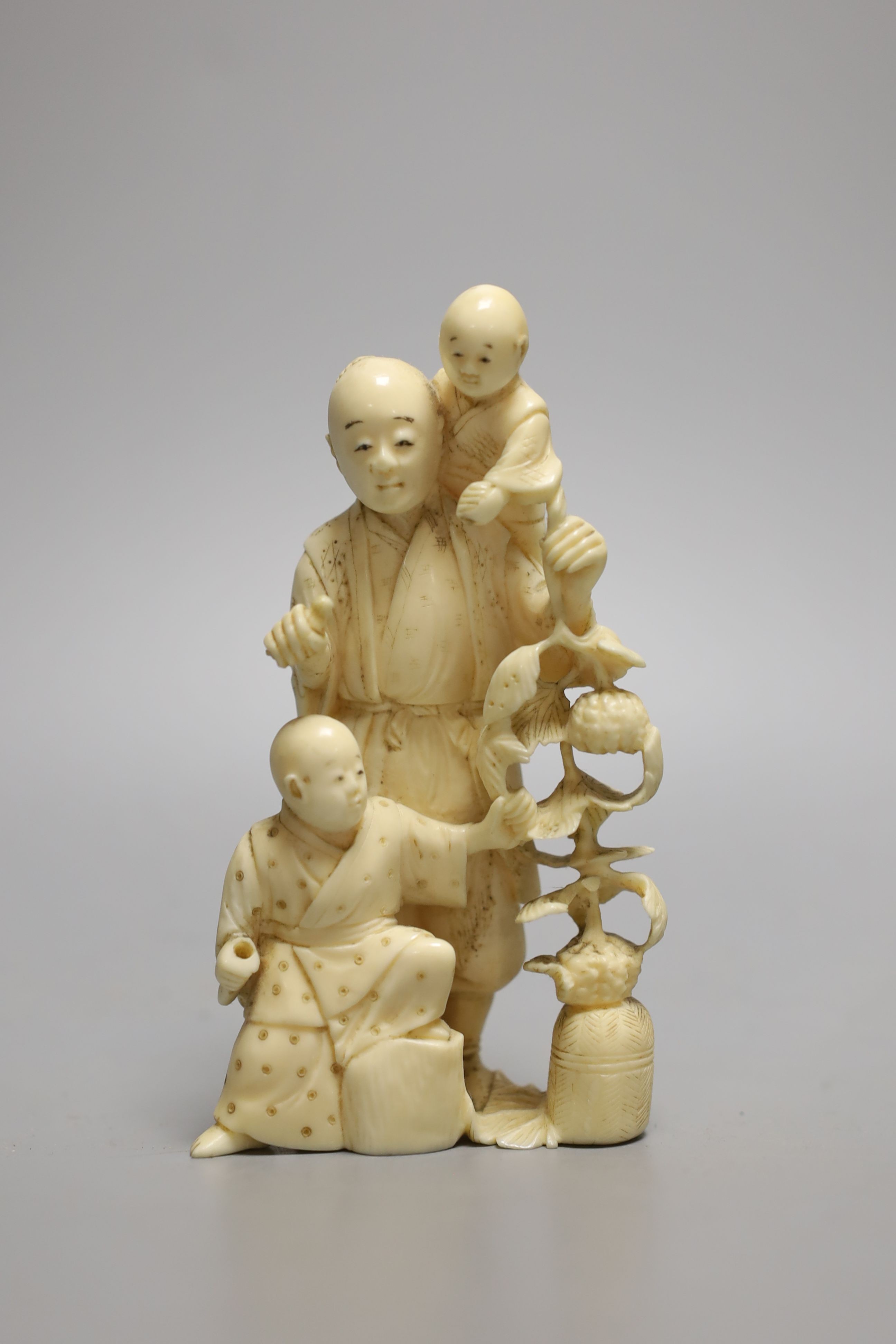 A Japanese carved ivory okimono of a farmer and two boys, Meiji period - 12.5cm tall